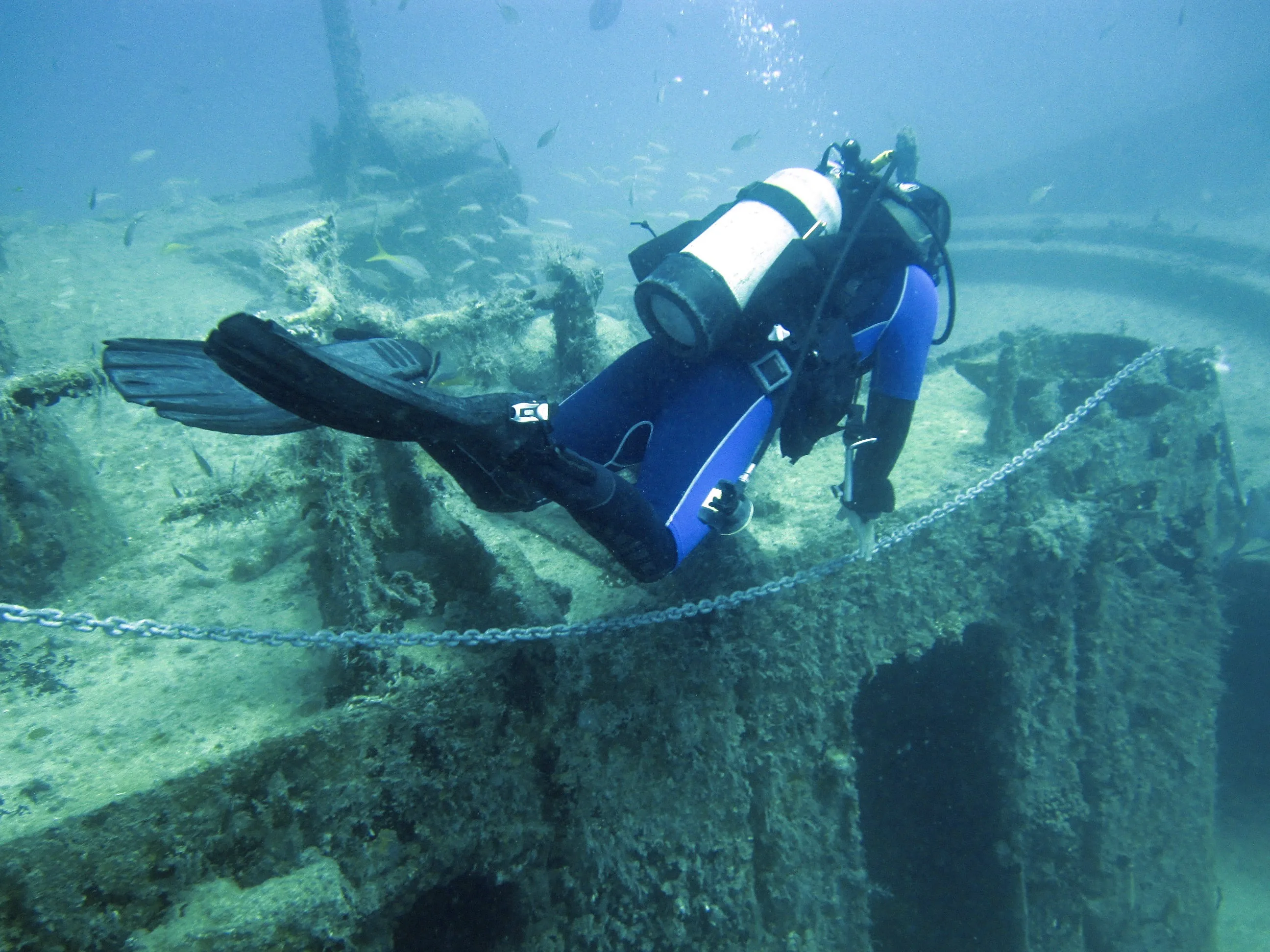 FiveMeters restoration of Diver over the Varadero wreck: Neutral metal tank and tan wreck growth return while distant structure stays cooler and softer.